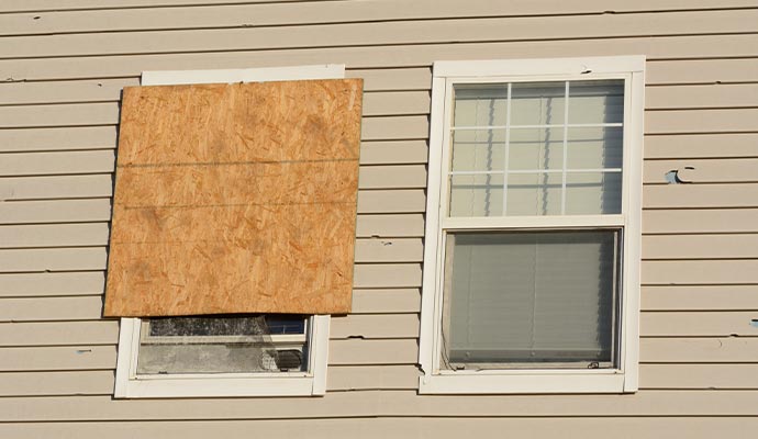  boarded-up window and hail storm damage