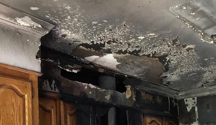 Damaged kitchen ceiling because of smoke and fire